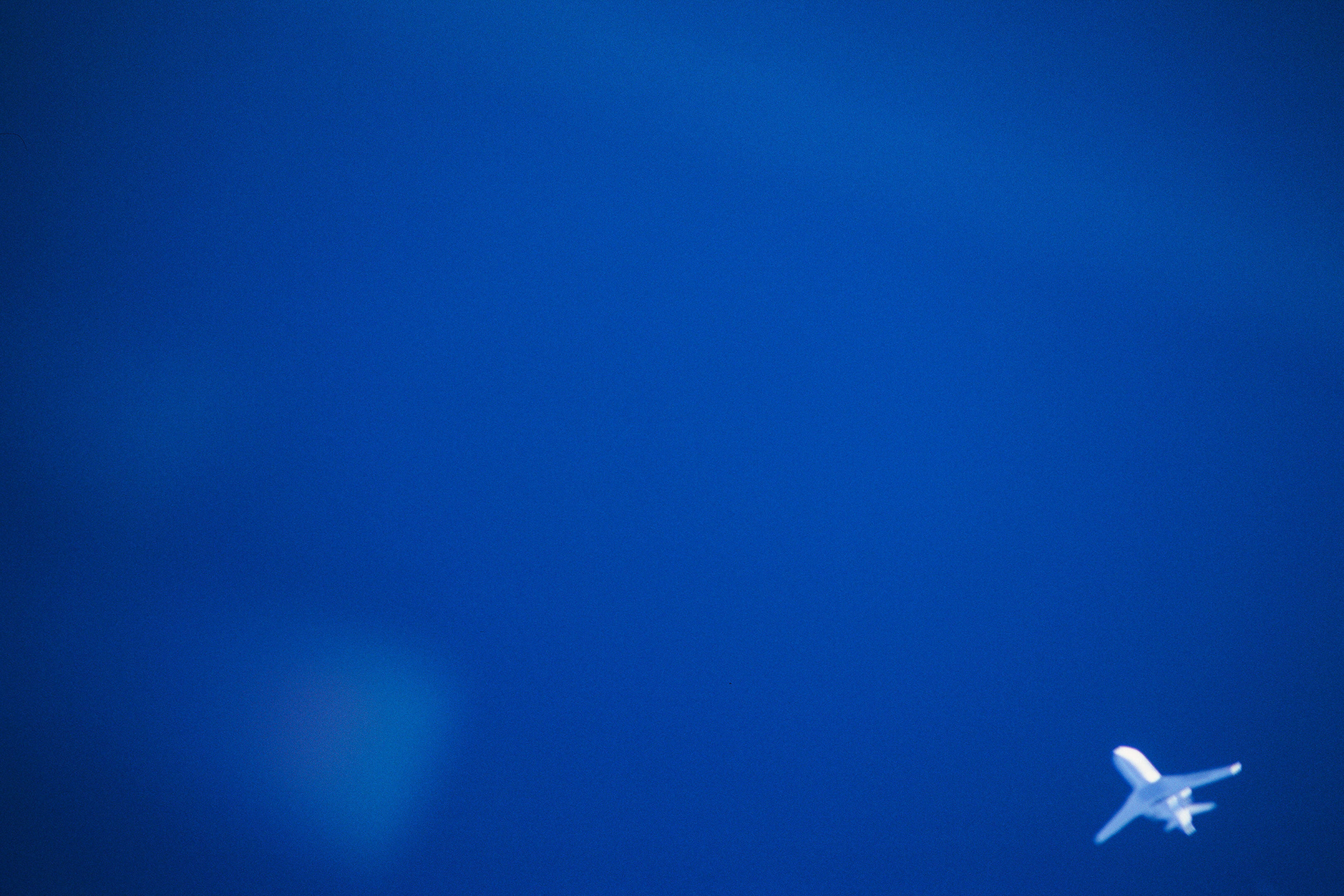 Blue sky and with white airplane in the right bottom corner